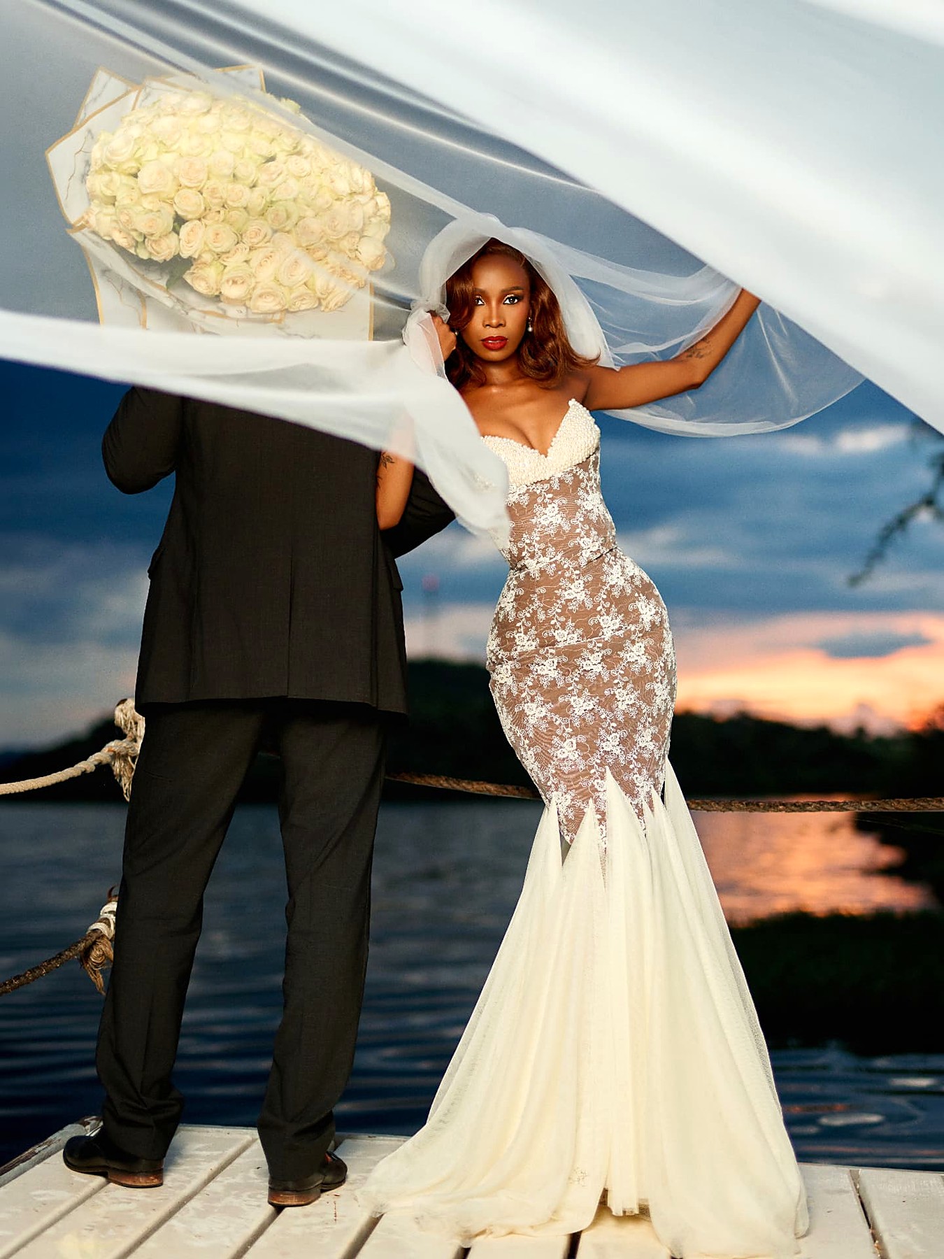 Foxxy bride in a pearl-domed mermaid gown with veil at sunset