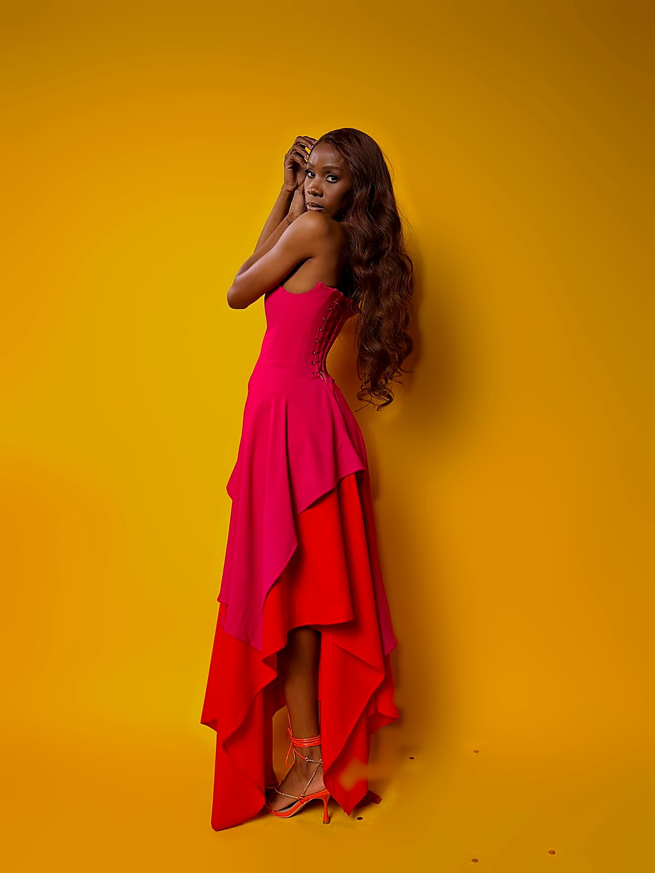 Hot pink corset gown with laced back over a bright orange high-low crepe skirt
